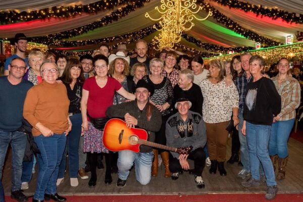 Robby Longo met guitar omringd van fans